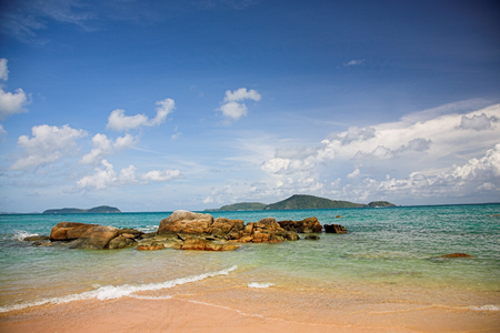 Tropical beach with small stones and waves on the foregroundの写真素材