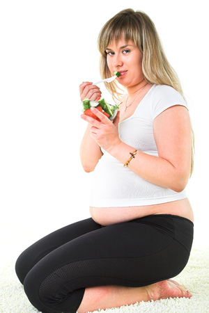 pregnant woman eating fresh vegetablesの写真素材
