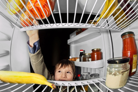 boy takes food from the refrigeratorの写真素材