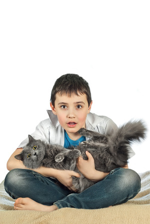 Boy with a gray cat on a white backgroundの写真素材