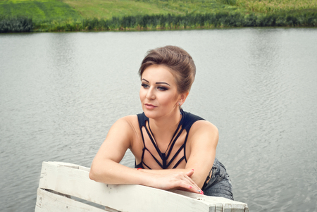 Girl resting on the lake in the summer aloneの写真素材