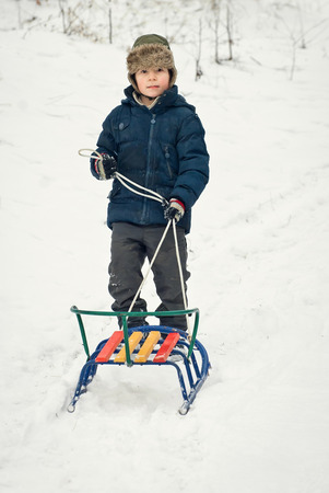 children are riding sledges in winter in the fresh air, on holidaysの写真素材