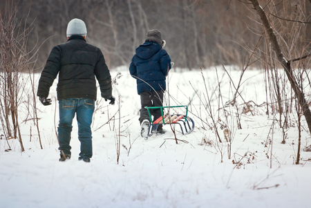 children are riding sledges in winter in the fresh air, on holidaysの写真素材