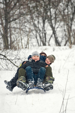 children are riding sledges in winter in the fresh air, on holidaysの写真素材