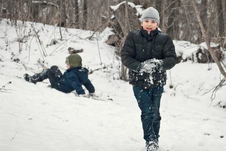 the guys are playing in the snow in the winter with emotionsの写真素材