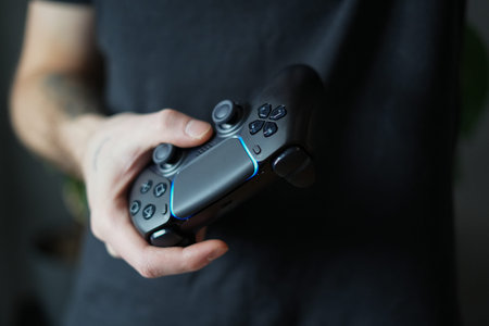 Man playing video game with joystick. Close up of male hands holding controller.