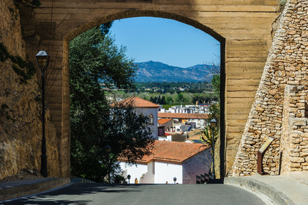 The town and the mountains through a gate in Tortosa, Catalonia, Spain