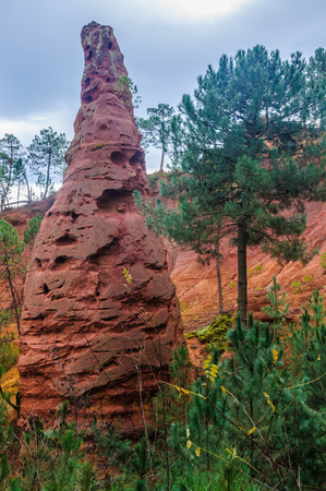 Reddish rock formations made of ochre near the hilltop village of Rousillon, Provence, France