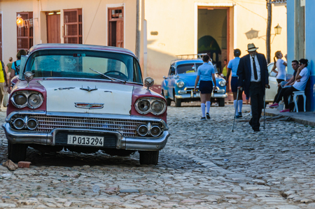 Old car and a local manon the cobblestone streets in the old town of Trinidad, Cubaのeditorial素材