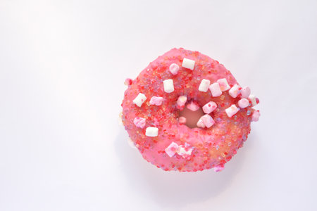 Pink donut with sprinkles isolated on white background, top viewの写真素材