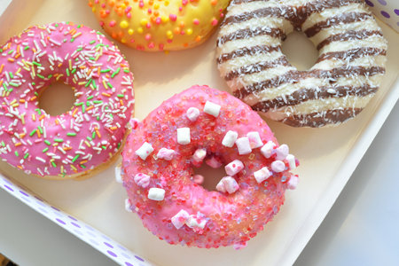 Donuts with chocolate frosted, pink glazed and sprinkles donuts.の写真素材