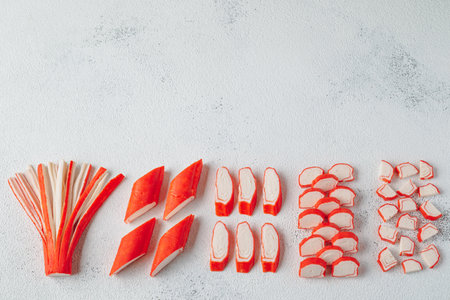 Creative layout made of cut crab sticks on concrete background. Flat lay, top view.の写真素材