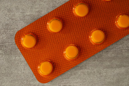 Orange or yellow pills on table, top view or close-up of pillsの写真素材