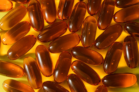 Omega 3 capsules on yellow bright background, close-up view of Omega 3の写真素材