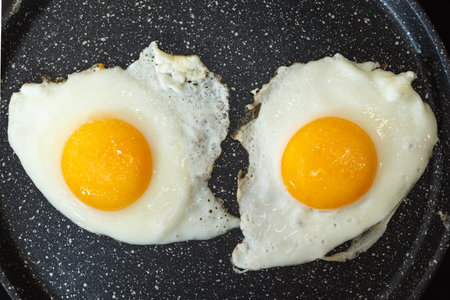Fried eggs in a frying pan on electric stove top view.の写真素材