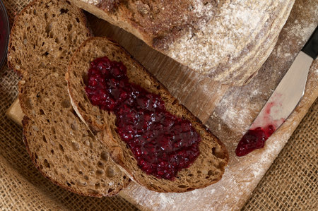 Rye bread slices spread with fruit jam on it top view, food background concept