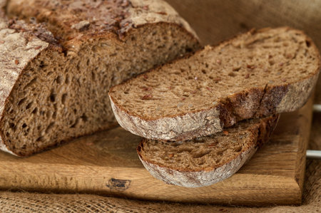 Rye bread cut or slices on wooden board and on burlapの写真素材
