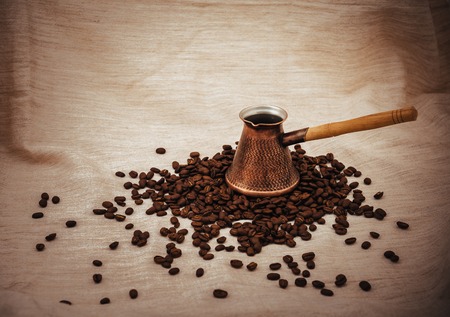 Coffee turk and cup of coffee on burlap background. coffee beans isolated on white background. roasted coffee beansの写真素材