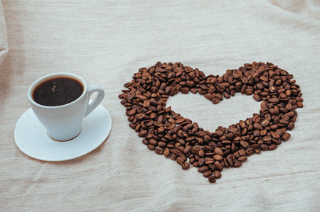 Cup of Coffe. Coffee beans in shape of heart. coffee beans isolated on white background. roasted coffee beans, can be used as a background.の写真素材
