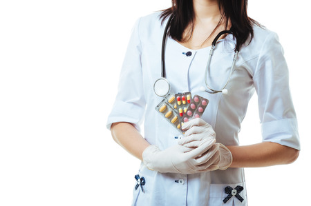 Young and friendly woman doctor holding and offering pills isolated on white background.の写真素材