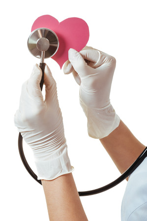 Positive female doctor standing with stethoscope and red heart symbol isolated on white background.の写真素材