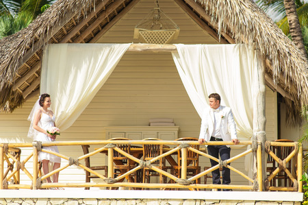 young loving couple on tropical sea background - wedding on beach. Just-married couple standing by blue lagoon.の写真素材