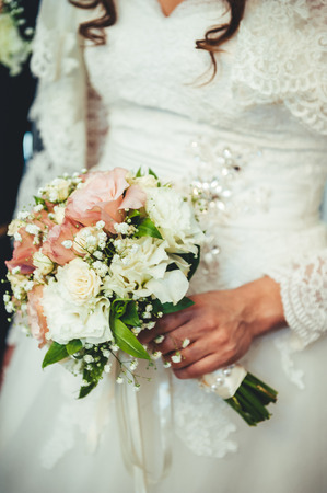 Wedding bouquet of flowers, close up. Young wedding couple indoors portraitの写真素材