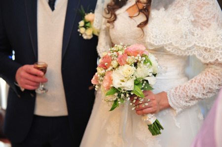 Wedding bouquet of flowers, close up. Young wedding couple indoors portraitの写真素材