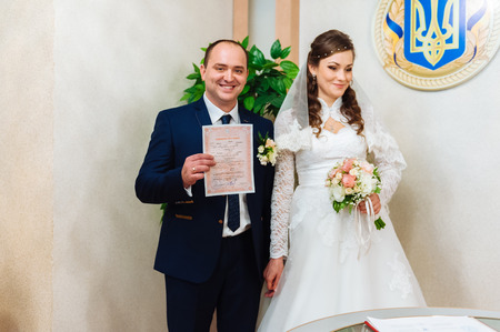 The marriage register. Bride and Groom Signing Marriage Certificate. Young couple signing wedding documentsの写真素材