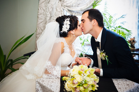 Wedding couple sitting in a cafe on their wedding day.の写真素材