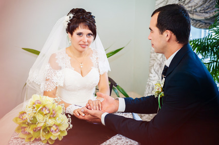 Wedding couple sitting in a cafe on their wedding day.の写真素材