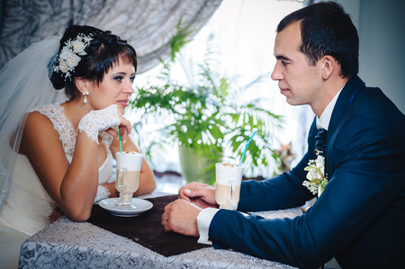  Newly wed couple drinking cappuccino in cafeの写真素材