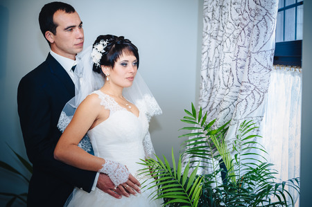 Charming bride and groom on their wedding celebration in a luxurious restaurant. Wedding bouquet of flowers and bridal dress. newly married couple in luxury modern hotel hallの写真素材