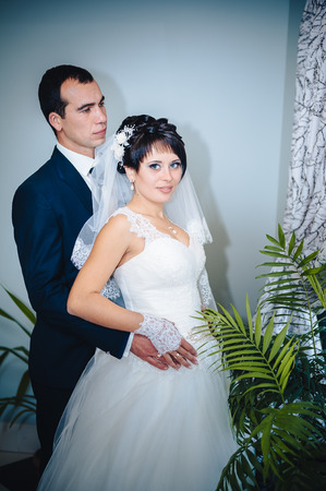 Charming bride and groom on their wedding celebration in a luxurious restaurant. Wedding bouquet of flowers and bridal dress. newly married couple in luxury modern hotel hallの写真素材