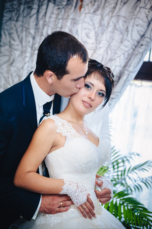 Charming bride and groom on their wedding celebration in a luxurious restaurant. Wedding bouquet of flowers and bridal dress. newly married couple in luxury modern hotel hallの写真素材
