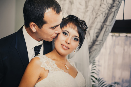 Charming bride and groom on their wedding celebration in a luxurious restaurant. Wedding bouquet of flowers and bridal dress. newly married couple in luxury modern hotel hallの写真素材