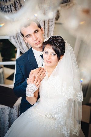 Charming bride and groom on their wedding celebration in a luxurious restaurant. Wedding bouquet of flowers and bridal dress. newly married couple in luxury modern hotel hallの写真素材