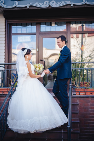 Bride and groom standing on stairs. an image of bride and groom the stairs outdoorsの写真素材