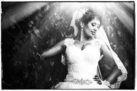 portrait of beautiful young bride holding bright bouquet of flowers in hands. wedding celebration. reception. nature green background. woman alone outdoors in park.の写真素材