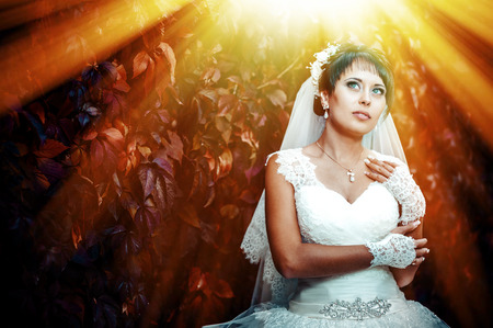 portrait of beautiful young bride holding bright bouquet of flowers in hands. wedding celebration. reception. nature green background. woman alone outdoors in park.の写真素材