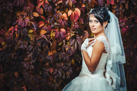 portrait of beautiful young bride holding bright bouquet of flowers in hands. wedding celebration. reception. nature green background. woman alone outdoors in park.の写真素材