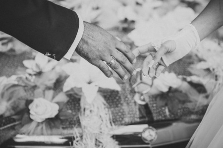 hands of the bride and groom and wedding bouquet on black box carの写真素材