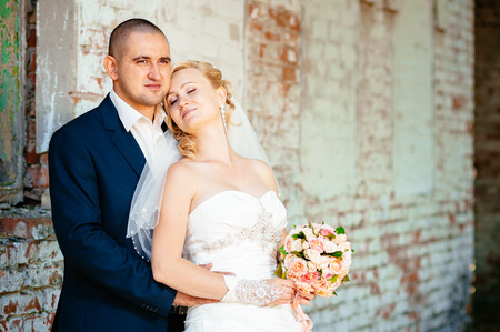 Happy young bride and groom outdoors in the park on their wedding day. Wedding couple - new family! wedding dress. Bridal wedding bouquet of flowersの写真素材