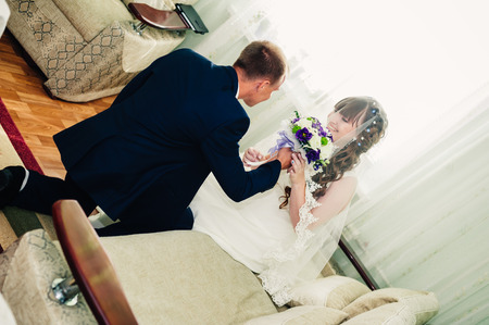 Young wedding couple indoors portrait. Charming bride and groom on their wedding celebration in a luxurious restaurant.の写真素材