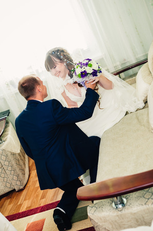 Young wedding couple indoors portrait. Charming bride and groom on their wedding celebration in a luxurious restaurant.の写真素材