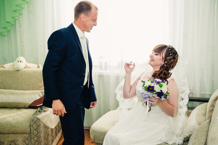 Young wedding couple indoors portrait. Charming bride and groom on their wedding celebration in a luxurious restaurant.の写真素材