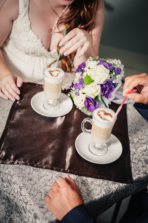 Cappuccino or latte coffee with heart shape. bride and groom  in a luxurious restaurant drink a cup of Coffee latte on the date. Coffee latte with heart design on their wedding or Valentines dayの写真素材