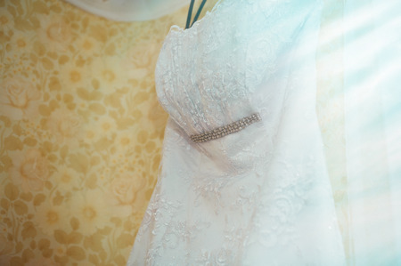 White Wedding dress hanging on a shoulders, before ceremonyの写真素材