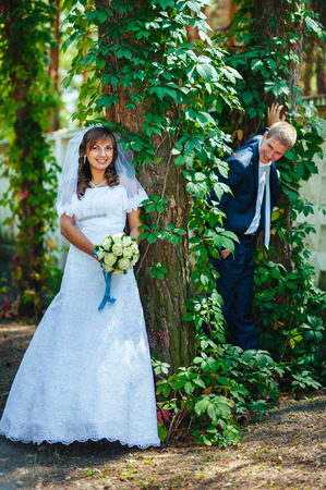 Bride and Groom at wedding Day walking Outdoors on spring nature. Bridal couple, Happy Newlywed woman and man embracing in green park. Loving wedding couple outdoor.の写真素材