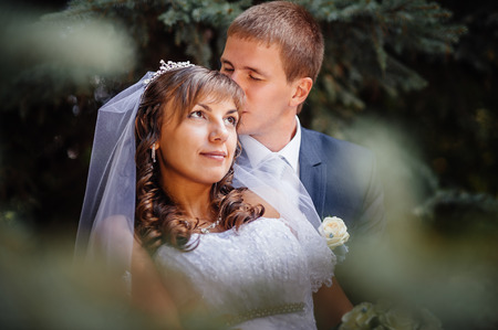 Bride and Groom at wedding Day walking Outdoors on spring nature. Bridal couple, Happy Newlywed woman and man embracing in green park. Loving wedding couple outdoor.の写真素材